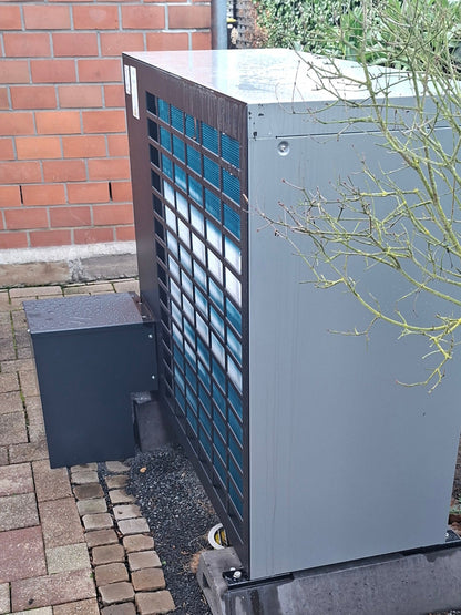 Detailaufnahme der anthrazitfarbenen Bodenabdeckhaube an Bosch Wärmepumpe im Garten, wetterfeste und langlebige Metall-Abdeckung für Wärmepumpen