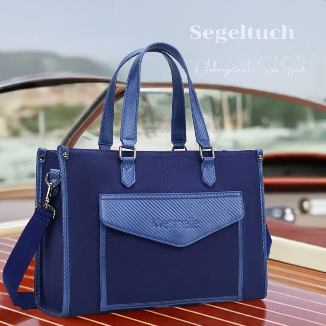 Blaue große Damenhandtasche aus Baumwollstoff mit blauem Leder steht auf einer Riva Yacht